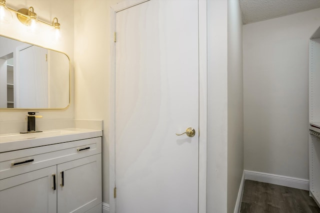 1673 Bay Rd Unit 206, Miami Beach, FL 33139 - bathroom featuring wood finished floors, baseboards, vanity, and a textured ceiling