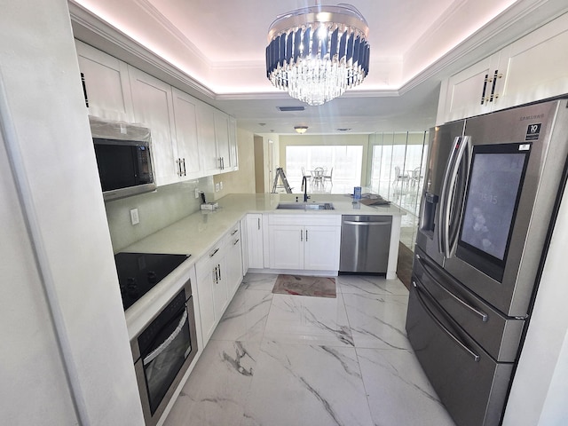 1731 Presidential Way Unit C201, West Palm Beach, FL 33401 - kitchen featuring stainless steel appliances, a tray ceiling, a chandelier, light marble finish flooring, and crown molding