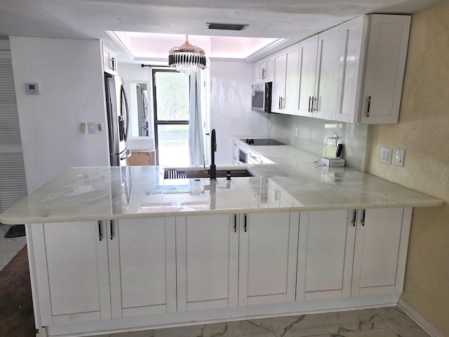1731 Presidential Way Unit C201, West Palm Beach, FL 33401 - kitchen featuring a peninsula, black electric stovetop, stainless steel fridge with ice dispenser, marble finish flooring, and white cabinetry