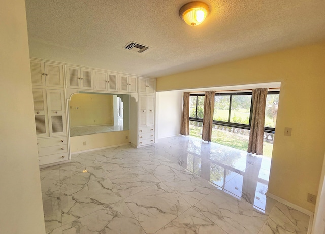 1731 Presidential Way Unit C201, West Palm Beach, FL 33401 - spare room with light marble finish flooring and a textured ceiling