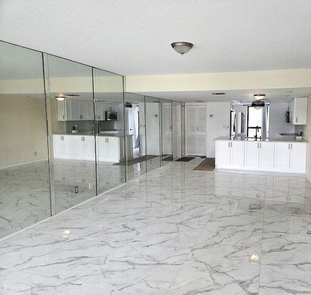 1731 Presidential Way Unit C201, West Palm Beach, FL 33401 - unfurnished room with light marble finish floors and a textured ceiling