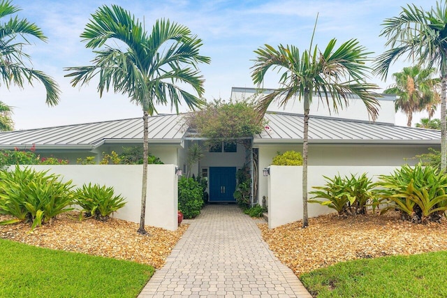2150 SE Golfview Ln, Stuart, FL 34996 - entrance to property with a standing seam roof, metal roof, stucco siding, and a gate