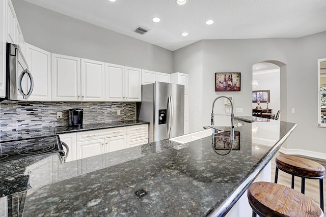 17233 Bermuda Village Dr, Boca Raton, FL 33487 - kitchen featuring appliances with stainless steel finishes, arched walkways, backsplash, recessed lighting, and a breakfast bar area
