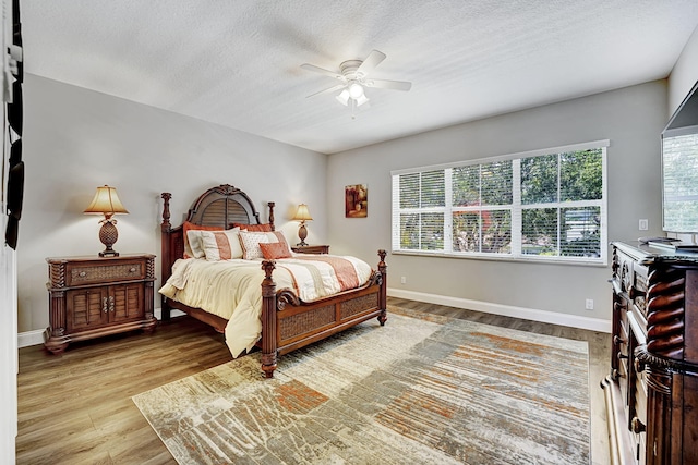 17233 Bermuda Village Dr, Boca Raton, FL 33487 - bedroom with wood finished floors, baseboards, a textured ceiling, and ceiling fan