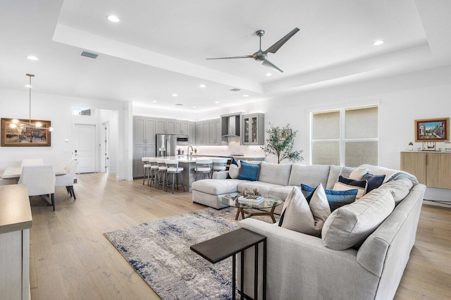 13487 Whistler Mountain Rd, Delray Beach, FL 33446 - living area featuring a tray ceiling, a ceiling fan, recessed lighting, and light wood finished floors