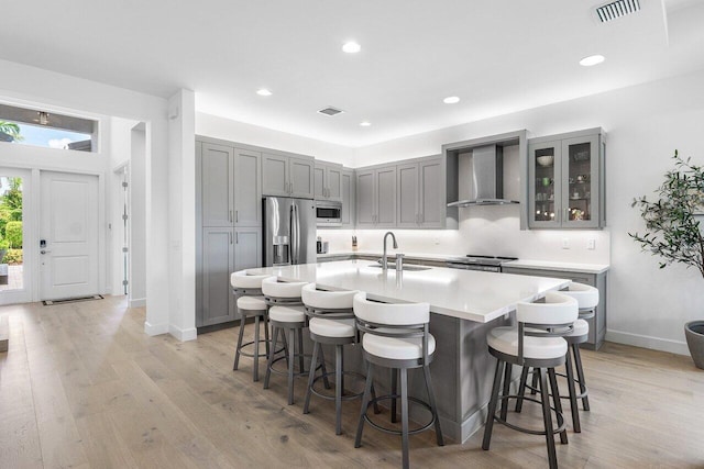 13487 Whistler Mountain Rd, Delray Beach, FL 33446 - kitchen with wall chimney exhaust hood, stainless steel appliances, a sink, gray cabinetry, and a breakfast bar area