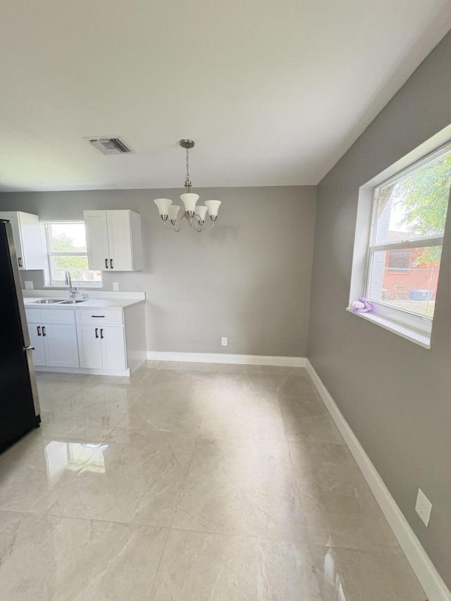 324W W 5th Ter, Pahokee, FL 33476 - kitchen with a chandelier, freestanding refrigerator, baseboards, a sink, and hanging light fixtures