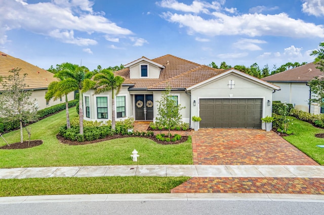 314 Sonoma Isles Cir, Jupiter, FL 33478 - mediterranean / spanish-style house with stucco siding, an attached garage, a tiled roof, driveway, and a front lawn
