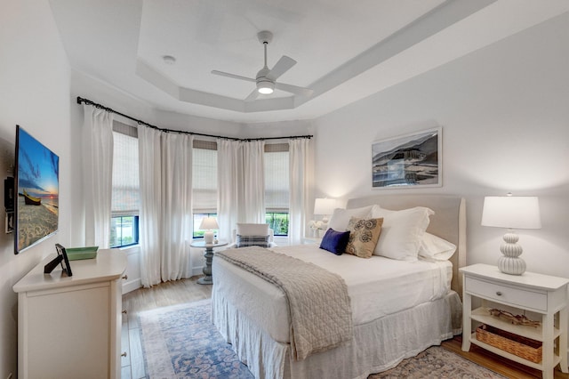 314 Sonoma Isles Cir, Jupiter, FL 33478 - bedroom with multiple windows, light wood-style flooring, a tray ceiling, and ceiling fan