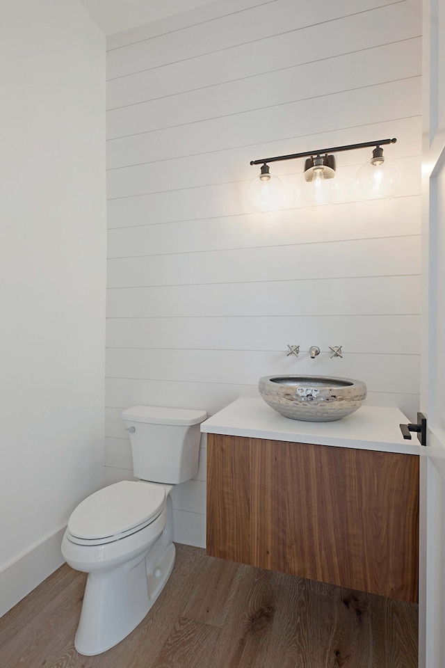 18072 127th Dr N, Jupiter, FL 33478 - half bathroom with wood finished floors, vanity, toilet, and baseboards