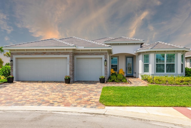 10339 SW Tetian Dr, Port Saint Lucie, FL 34987 - view of front of property with decorative driveway, a garage, a front yard, a tiled roof, and stucco siding
