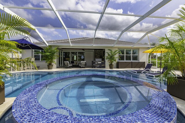 10339 SW Tetian Dr, Port Saint Lucie, FL 34987 - view of pool featuring a pool with connected hot tub, a ceiling fan, a patio area, and glass enclosure