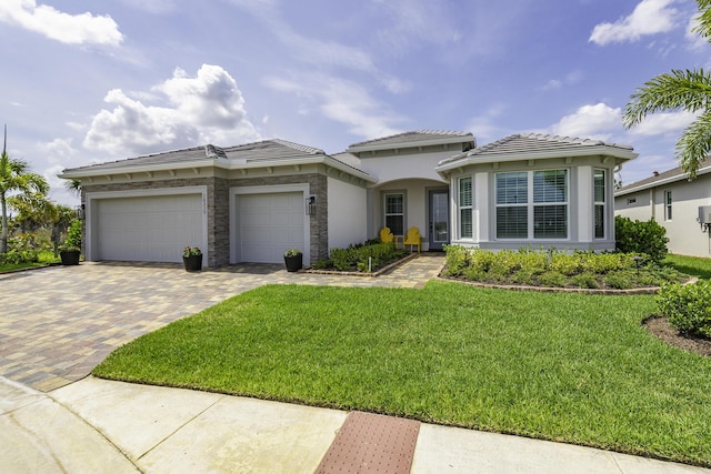 10339 SW Tetian Dr, Port Saint Lucie, FL 34987 - mediterranean / spanish-style house featuring decorative driveway, a garage, a front lawn, and a tiled roof