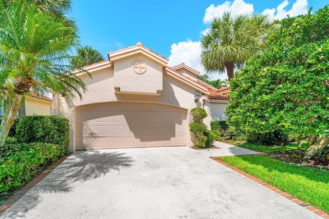 16703 Hidden Cove Dr, Jupiter, FL 33477 - mediterranean / spanish-style house with stucco siding, a tiled roof, driveway, and a garage