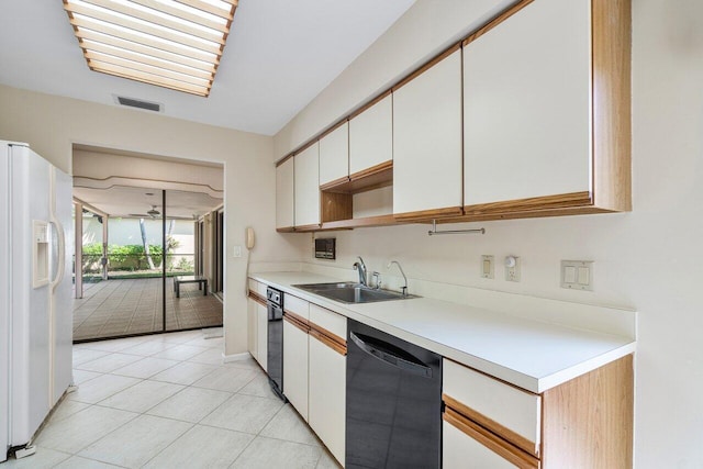 16703 Hidden Cove Dr, Jupiter, FL 33477 - kitchen with black dishwasher, a sink, white refrigerator with ice dispenser, light countertops, and white cabinetry