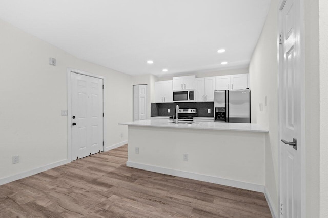 1825 Palm Cove Blvd Unit 7-307, Delray Beach, FL 33445 - kitchen with appliances with stainless steel finishes, wood finished floors, white cabinets, recessed lighting, and light countertops
