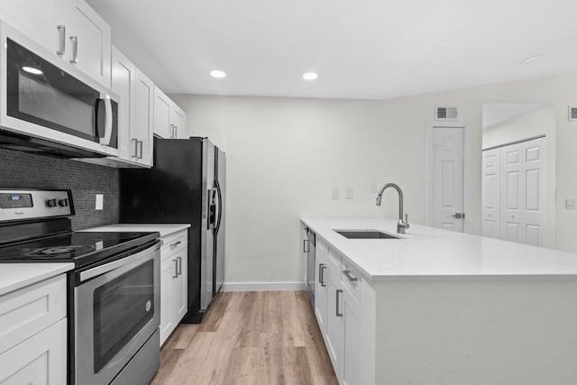 1825 Palm Cove Blvd Unit 7-307, Delray Beach, FL 33445 - kitchen featuring stainless steel electric stove, white microwave, a sink, a peninsula, and light wood-style floors