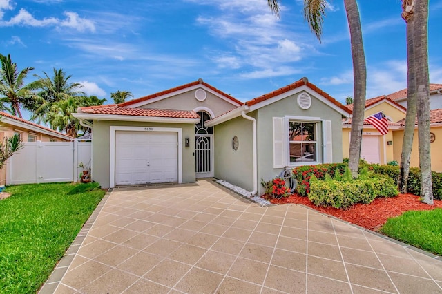 5630 Eagle Trace Ct, Lake Worth, FL 33463 - mediterranean / spanish-style home featuring driveway, an attached garage, stucco siding, a tiled roof, and a gate