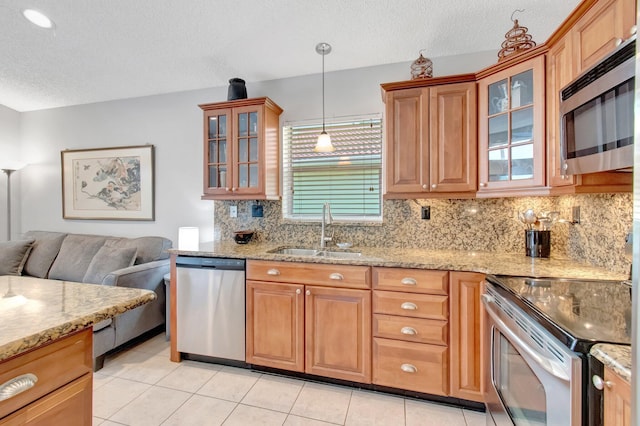 5630 Eagle Trace Ct, Lake Worth, FL 33463 - kitchen with appliances with stainless steel finishes, a sink, decorative backsplash, a textured ceiling, and light stone countertops