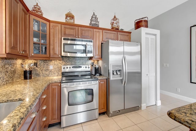5630 Eagle Trace Ct, Lake Worth, FL 33463 - kitchen featuring appliances with stainless steel finishes, tasteful backsplash, light tile patterned flooring, and brown cabinetry