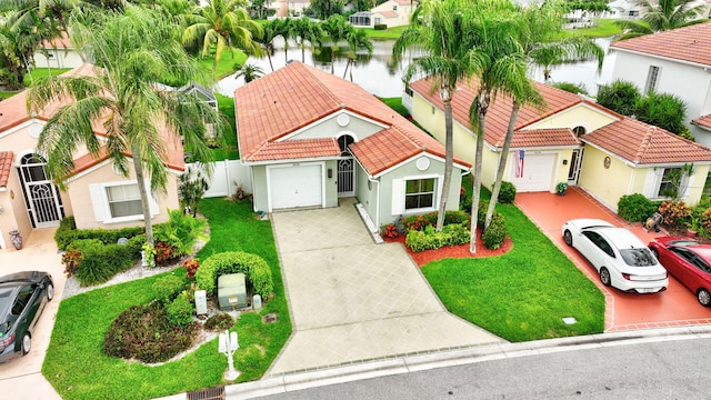 5630 Eagle Trace Ct, Lake Worth, FL 33463 - mediterranean / spanish home featuring an attached garage, a tile roof, concrete driveway, and a water view