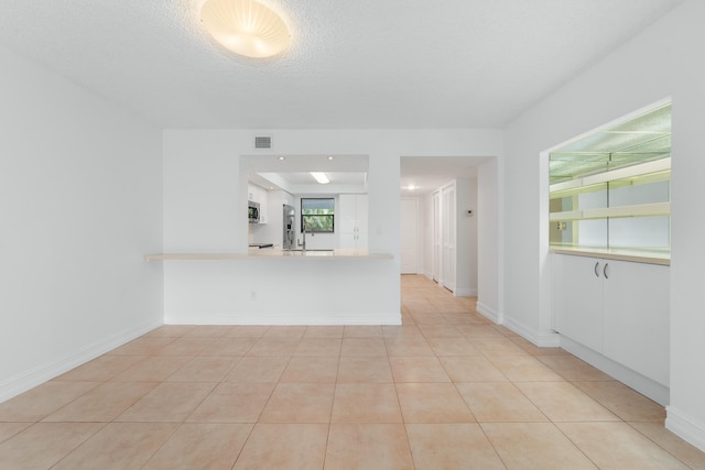 16091 Blatt Blvd Unit 302, Weston, FL 33326 - unfurnished living room featuring light tile patterned floors, baseboards, and a textured ceiling
