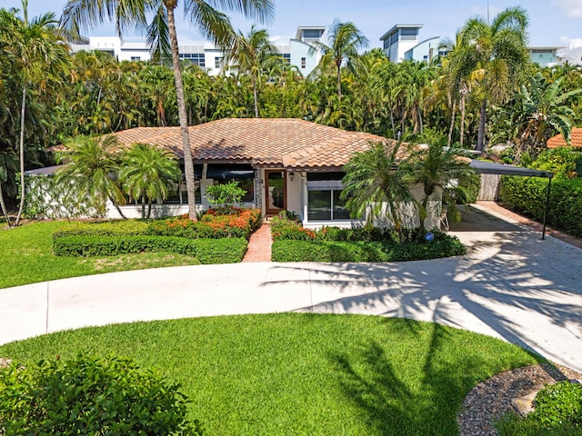330 SE 7th Ave, Delray Beach, FL 33483 - view of front of property with a tiled roof, a front lawn, driveway, stucco siding, and a detached carport