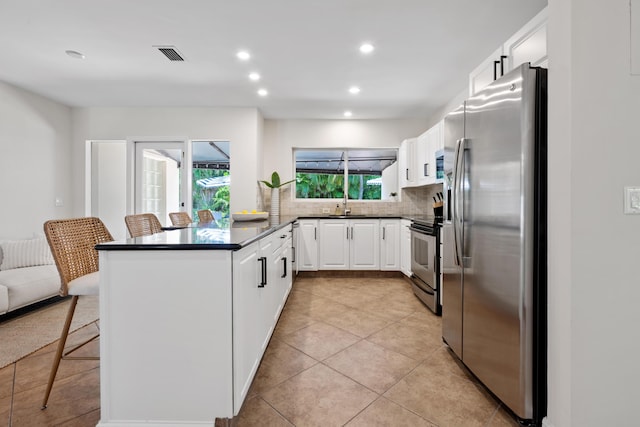 330 SE 7th Ave, Delray Beach, FL 33483 - kitchen with appliances with stainless steel finishes, dark countertops, tasteful backsplash, white cabinets, and recessed lighting