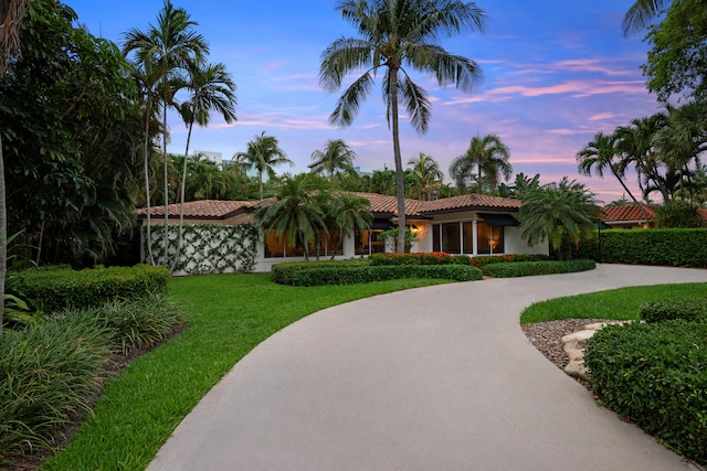 330 SE 7th Ave, Delray Beach, FL 33483 - view of front of property with curved driveway, a front yard, a tiled roof, and stucco siding
