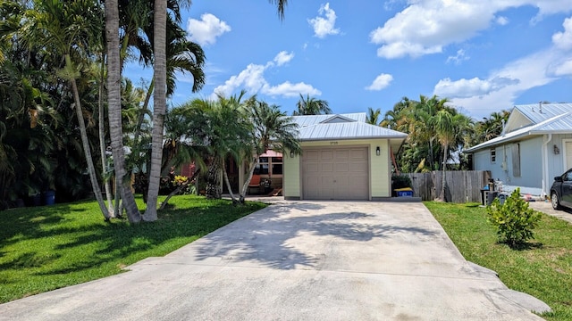 3725 SE Middle St, Stuart, FL 34997 - view of front of property featuring an attached garage, driveway, and metal roof