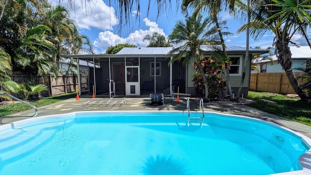 3725 SE Middle St, Stuart, FL 34997 - view of pool featuring a sunroom, a fenced backyard, and a patio area