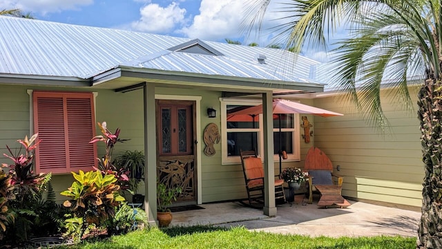 3725 SE Middle St, Stuart, FL 34997 - view of exterior entry featuring metal roof and a patio