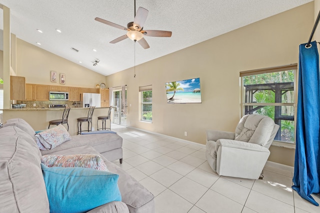 6815 NW 28th St, Margate, FL 33063 - living room with light tile patterned flooring, a textured ceiling, ceiling fan, high vaulted ceiling, and baseboards