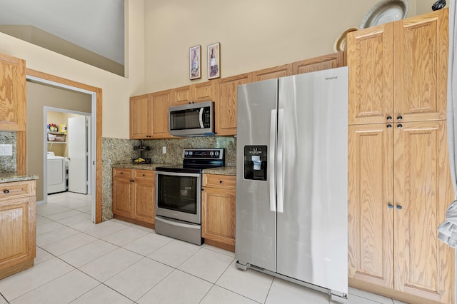 6815 NW 28th St, Margate, FL 33063 - kitchen with stainless steel appliances, washer / clothes dryer, light tile patterned floors, backsplash, and light stone countertops