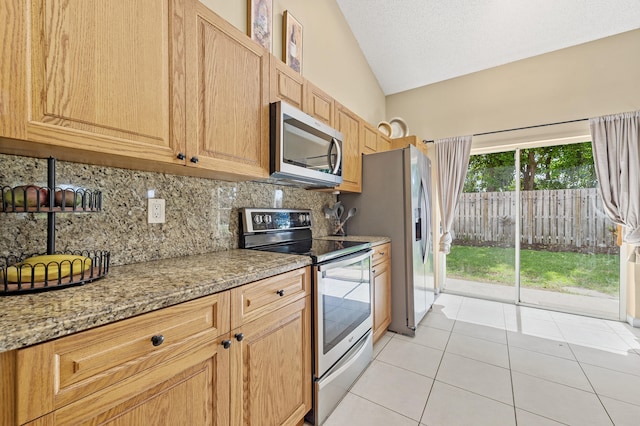 6815 NW 28th St, Margate, FL 33063 - kitchen with appliances with stainless steel finishes, vaulted ceiling, tasteful backsplash, light tile patterned floors, and light stone countertops