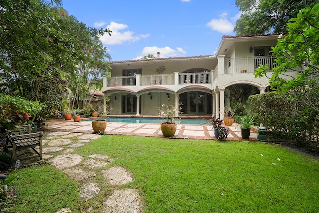 434 NW 7th Ave, Boca Raton, FL 33486 - rear view of property with french doors, a balcony, a lawn, a patio area, and an outdoor pool