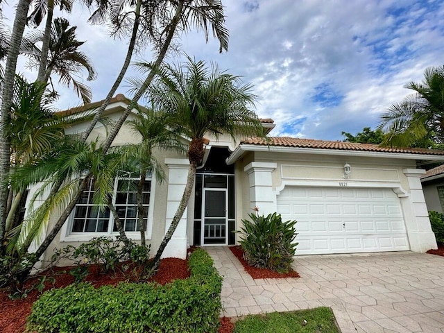 8825 Gibson Cay, West Palm Beach, FL 33411 - view of front of house featuring driveway, an attached garage, and stucco siding