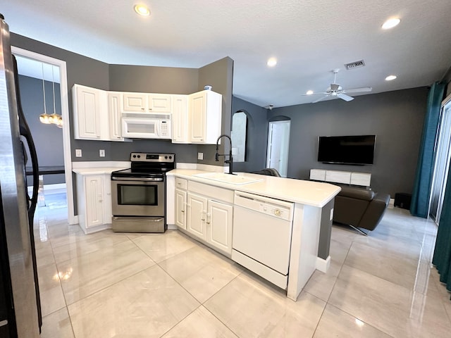8825 Gibson Cay, West Palm Beach, FL 33411 - kitchen with appliances with stainless steel finishes, a sink, a peninsula, arched walkways, and light countertops