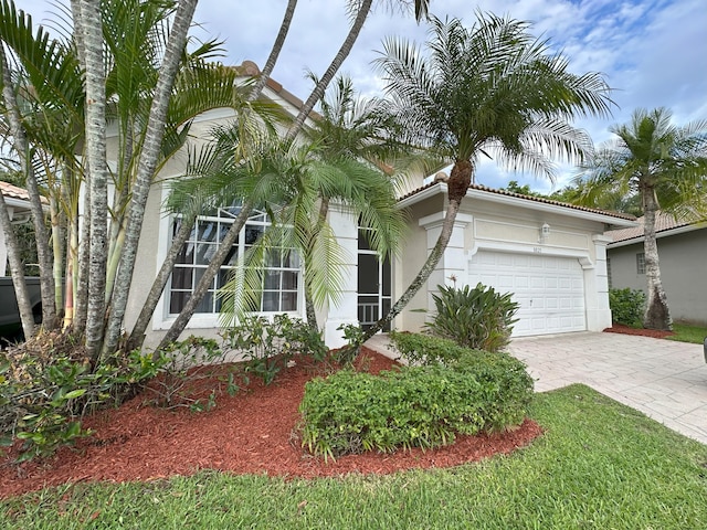 8825 Gibson Cay, West Palm Beach, FL 33411 - view of front of property featuring stucco siding, a garage, and decorative driveway