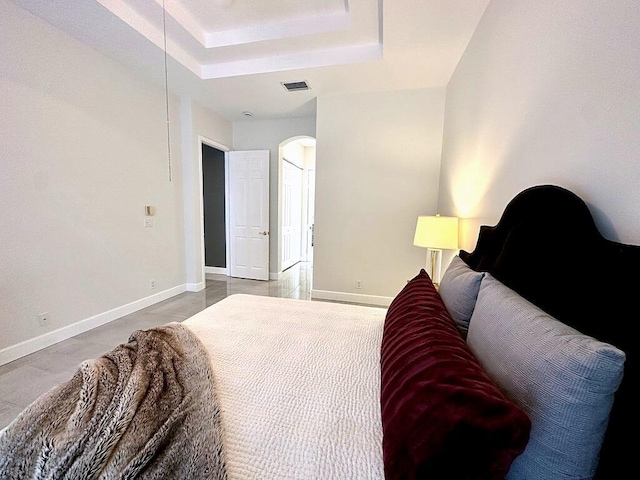 8825 Gibson Cay, West Palm Beach, FL 33411 - bedroom with arched walkways, a raised ceiling, and baseboards