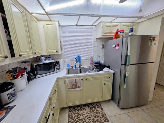 725 Lori Dr Unit 206, Palm Springs, FL 33406 - kitchen with stainless steel appliances, a sink, light countertops, light tile patterned floors, and backsplash