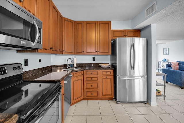 1 Harbourside Dr Unit 4506, Delray Beach, FL 33483 - kitchen featuring appliances with stainless steel finishes, a sink, brown cabinetry, and light tile patterned floors
