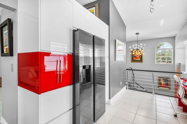 7685 Springwater Pl Unit 201, Boynton Beach, FL 33437 - corridor featuring an upstairs landing, a textured ceiling, light tile patterned floors, baseboards, and a chandelier