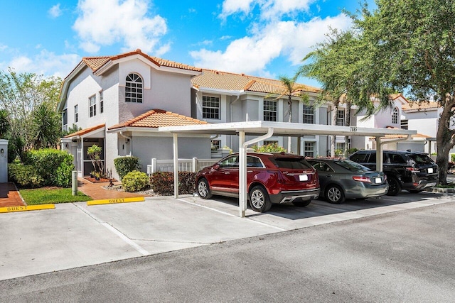 7685 Springwater Pl Unit 201, Boynton Beach, FL 33437 - view of property with a tile roof, covered and uncovered parking, and stucco siding