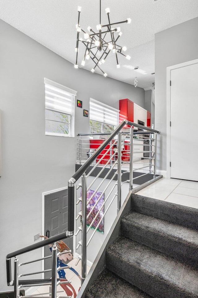 7685 Springwater Pl Unit 201, Boynton Beach, FL 33437 - staircase with a chandelier, a textured ceiling, and baseboards