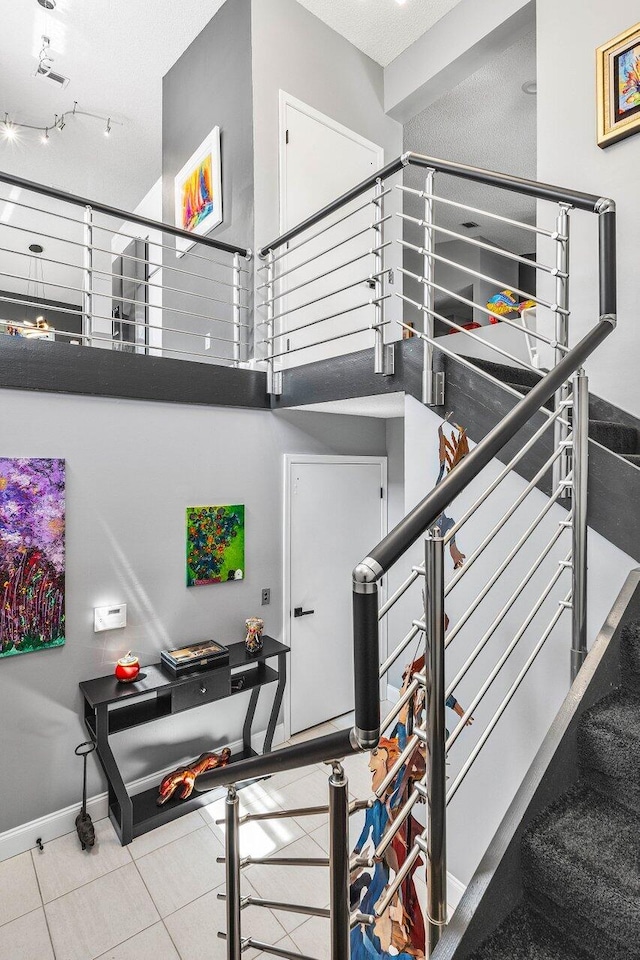 7685 Springwater Pl Unit 201, Boynton Beach, FL 33437 - stairway featuring baseboards, a high ceiling, and tile patterned flooring