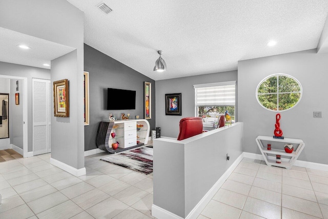 7685 Springwater Pl Unit 201, Boynton Beach, FL 33437 - living room with lofted ceiling, light tile patterned floors, recessed lighting, a textured ceiling, and baseboards
