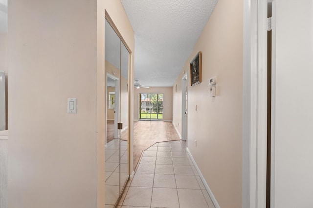 1953 SW Palm City Rd Unit 27-I, Stuart, FL 34994 - hall with light tile patterned floors, a textured ceiling, light colored carpet, and baseboards