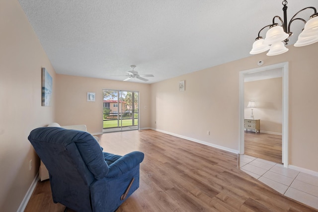 1953 SW Palm City Rd Unit 27-I, Stuart, FL 34994 - sitting room with ceiling fan, light wood-style floors, a textured ceiling, baseboards, and a chandelier