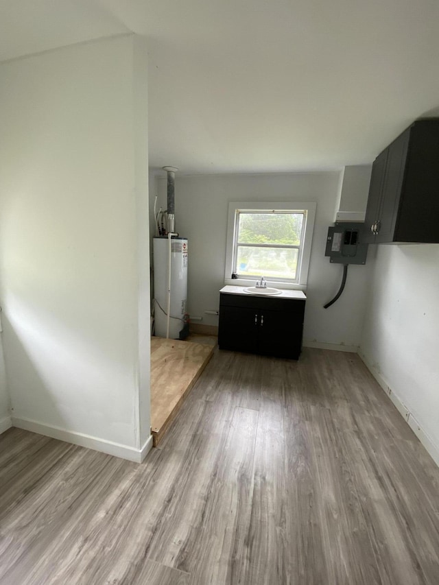 4235 Clay St, Marianna, FL 32446 - unfurnished dining area with water heater, a sink, light wood-style flooring, and baseboards